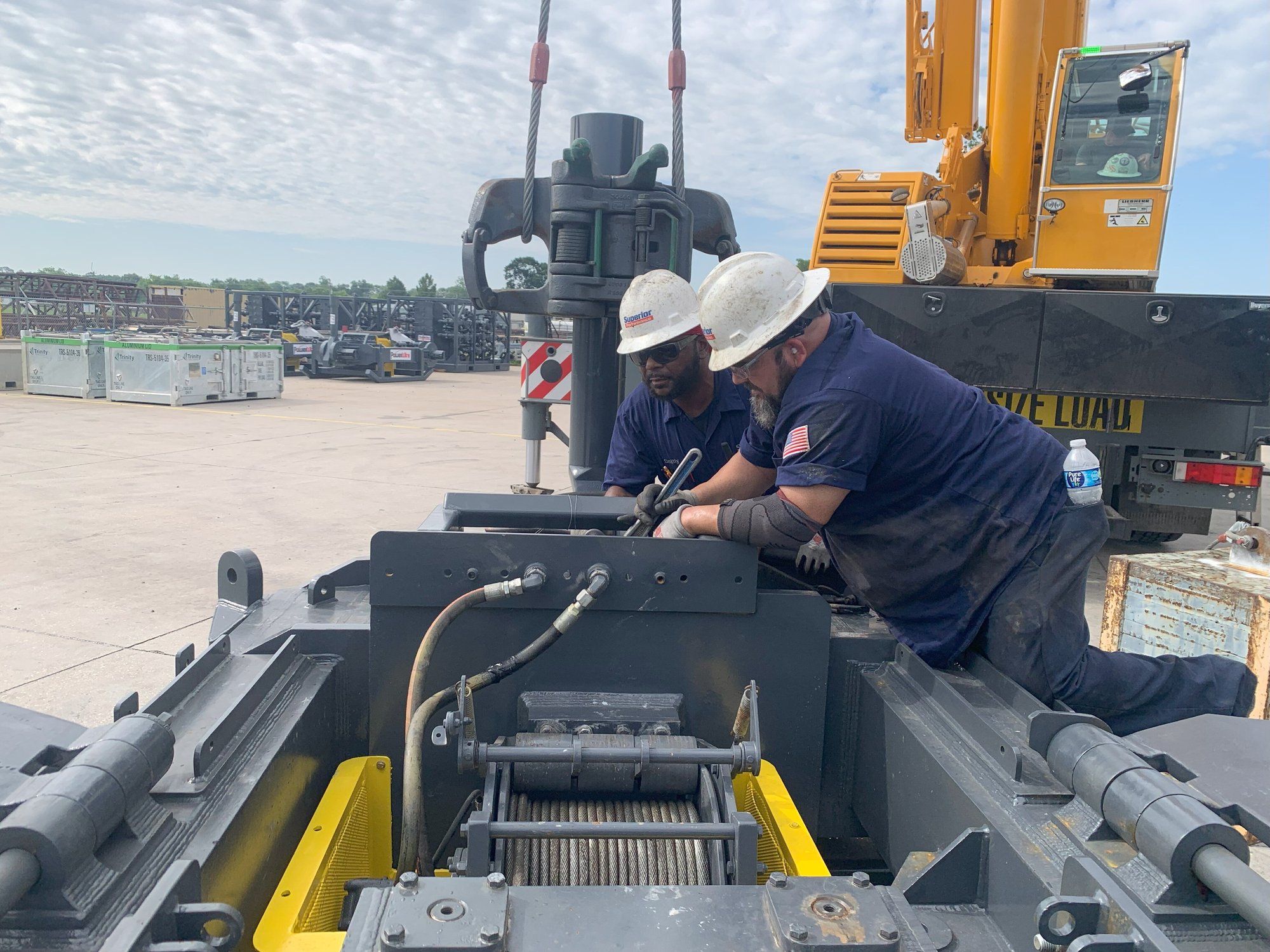 2 workers from Superior Performance tools inspecting a crane.