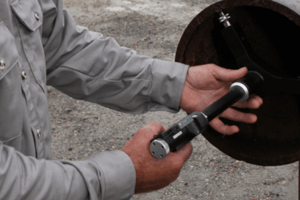 Technician using a casing ID caliper tool to measure internal diameter during casing inspection services.