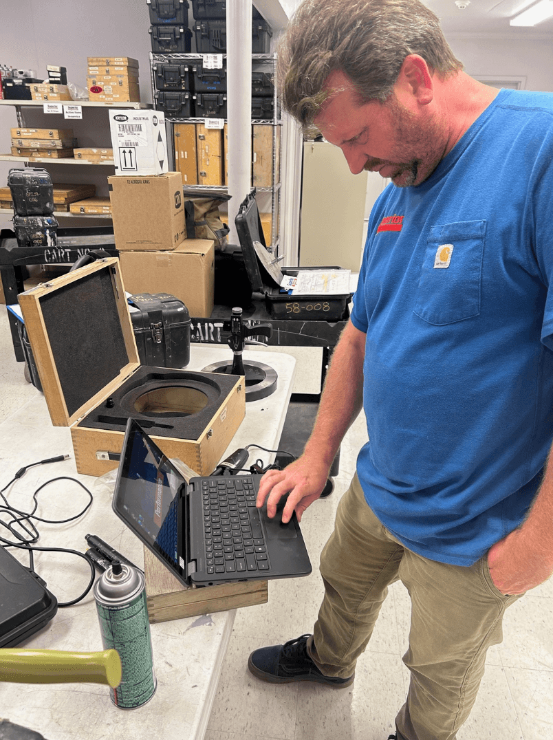 Superior Performance technician reviewing inspection data on a laptop during equipment testing and quality control.