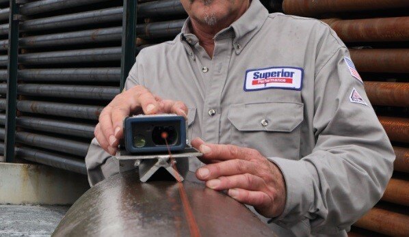 A offshore worker for Superior Performance tools using a laser tally to measure a pipe